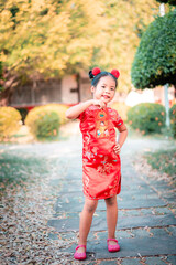cute little asian girl in chinese traditional dress smiling and holding red envelope.Happy chinese new year concept.