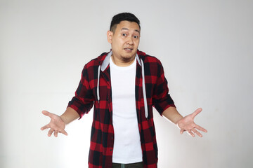 Young Asian man with shrug shoulder up gesture, showing i don't know or rejection