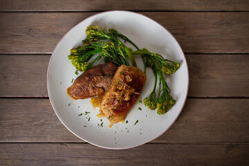 Roast duck breast fillets with vegetables on plate. Overhead horizontal image
