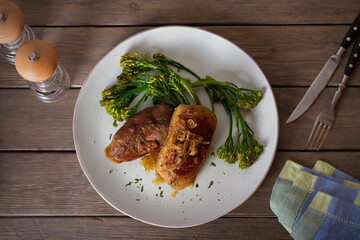 Roast duck breast fillets with vegetables on plate. Overhead horizontal image