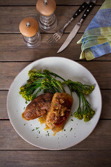 Roast duck breast fillets with vegetables on plate. Overhead vertical image