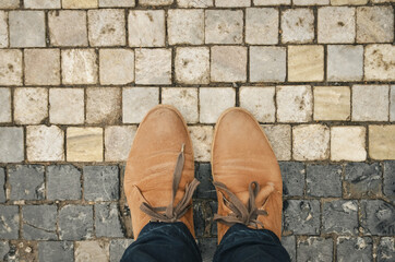 Brown man boots on the pavement from top. Copy space.