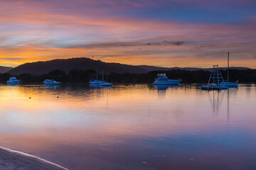 Naklejka premium Sunset at the waterfront with high cloud and boats