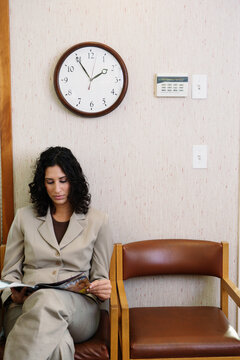 Young woman reading a magazine in waiting room
