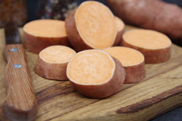 Sweet Potatoes on a wooden cutting board. Organic sweet potatoes for healthy eating. Closeup