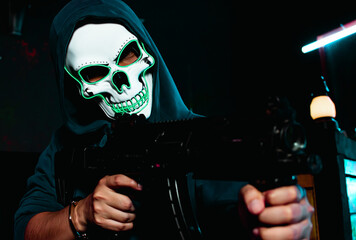 Scary murderer wearing skull mask and holding gun