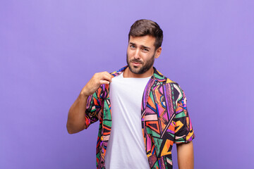 young man looking arrogant, successful, positive and proud, pointing to self