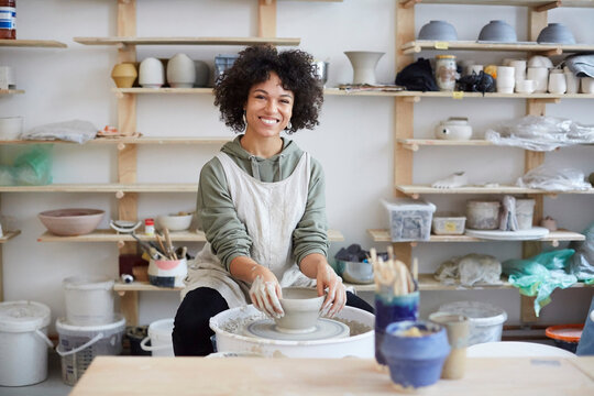 Portrait of smiling woman learning pottery in art studio