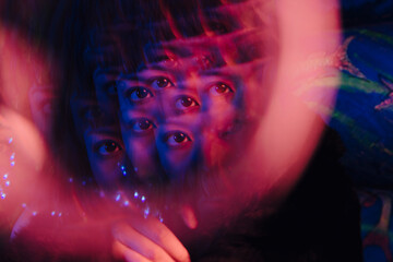 Multiple exposure of woman's eye at illuminated bar