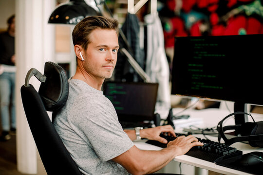 Portrait of male computer programmer working in office