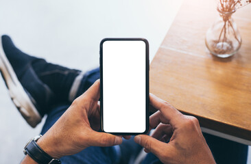 cell phone mockup blank white screen.man hand holding texting using mobile on desk at coffee shop.background empty space for advertise.work people contact marketing business,technology