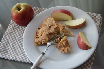 Apple pie on white plate. Apple and apple's pieces. Fork.