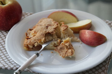 Apple pie on white plate. Apple and apple's pieces. Fork.