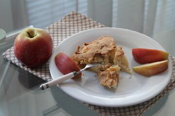 Apple pie on white plate. Apple and apple's pieces. Fork.