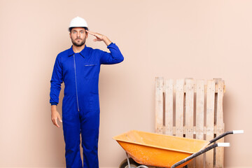 young man greeting the camera with a military salute in an act of honor and patriotism, showing respect construction concept