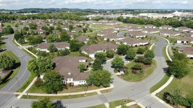 Descending aerial on single story homes and cottages in American retirement community, old peoples home, modern single story real estate living for senior citizen Boomers