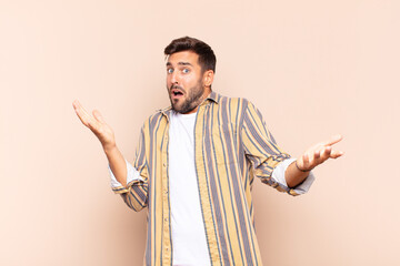 young man shrugging with a dumb, crazy, confused, puzzled expression, feeling annoyed and clueless