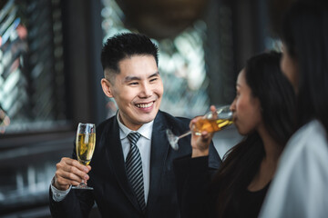 Cheers! Group of people cheering with champagne flutes in pub interior background