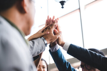 Large business team showing unity with their hands together, business success concept.