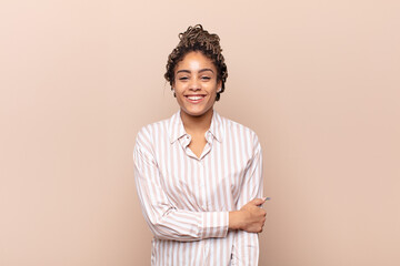 young afro woman laughing shyly and cheerfully, with a friendly and positive but insecure attitude
