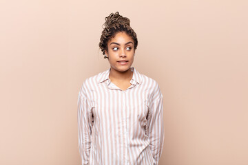 young afro woman looking worried, stressed, anxious and scared, panicking and clenching teeth