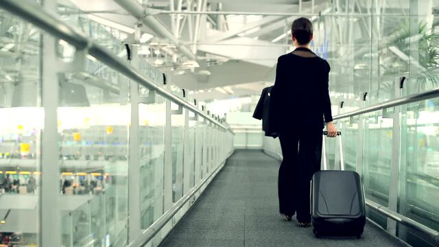 Elegant asian businesswoman with luggage in international airport terminal.