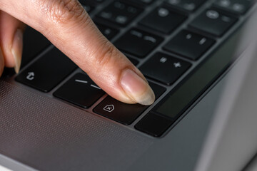 Obraz na płótnie Canvas close-up female hand pressing a Backspace key for delete on laptop keyboard