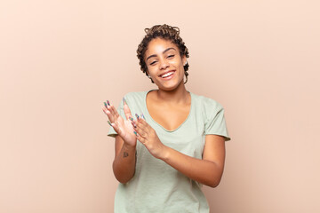 young afro woman feeling happy and successful, smiling and clapping hands, saying congratulations...