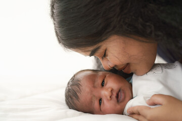 Obraz na płótnie Canvas mixed race african american and asian mother gentle kiss newborn baby