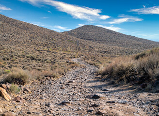 Rocks cover a rugged desert road up a hill in northern Nevada