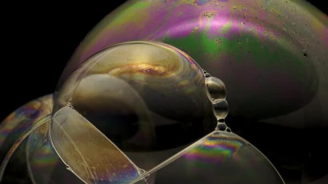 Close-up footage of a soap multiple bubbles surface with colorful and moving texture.