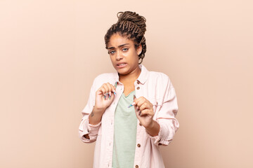 young afro woman feeling disgusted and nauseous, backing away from something nasty, smelly or...