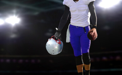 football player holding ball and helmet