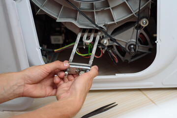 Handyman repairs the washer machine