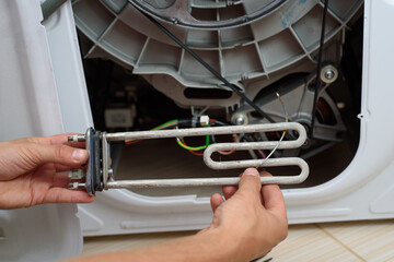 Handyman repairs the washer machine