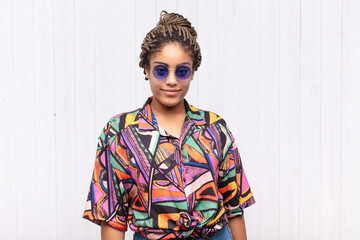 young afro woman looking proud, confident, cool, cheeky and arrogant, smiling, feeling successful