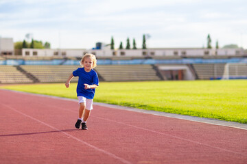 Fototapeta premium Child running in stadium. Kids run. Healthy sport.