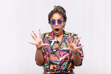 young afro woman feeling terrified, backing off and screaming in horror and panic, reacting to a...