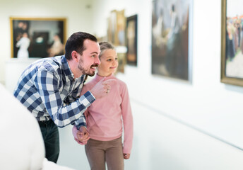 positive father and daughter regarding paintings in halls of museum