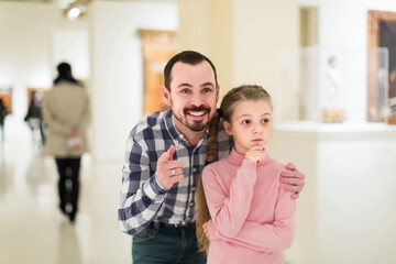 Fototapeta premium positive american father and daughter looking at paintings in halls of museum
