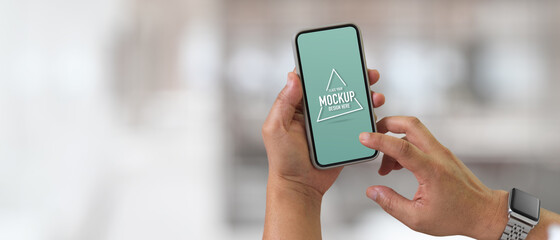 Male texting on mock up smartphone in blurred background