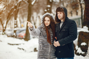 Obraz premium Cute couple walking in a winter city. Elegant woman in a gray fur coat