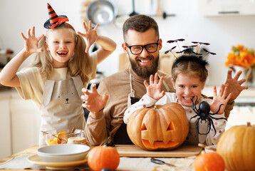 Father and daughters making scary faces during Halloween celebration