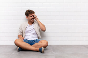 young man laughing and slapping forehead like saying d‚Äôoh! I forgot or that was a stupid...