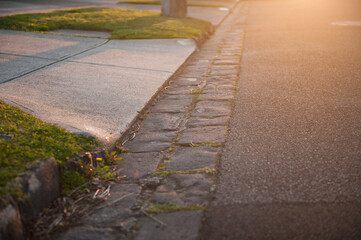 Asphalt road with a pavement lane and brick tiles. Sunset, outdoor.