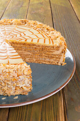 Cut caramel cake on plate on wooden table
