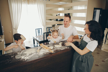 the family makes cakes. the children were covered in flour. dinner at the bakery. feast in the kitchen. mother's little helpers
