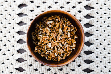 walnut kernels in wooden bowl on macrame placemats