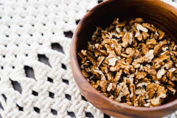 walnut kernels in wooden bowl on macrame placemats