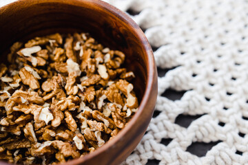walnut kernels in wooden bowl on macrame placemats